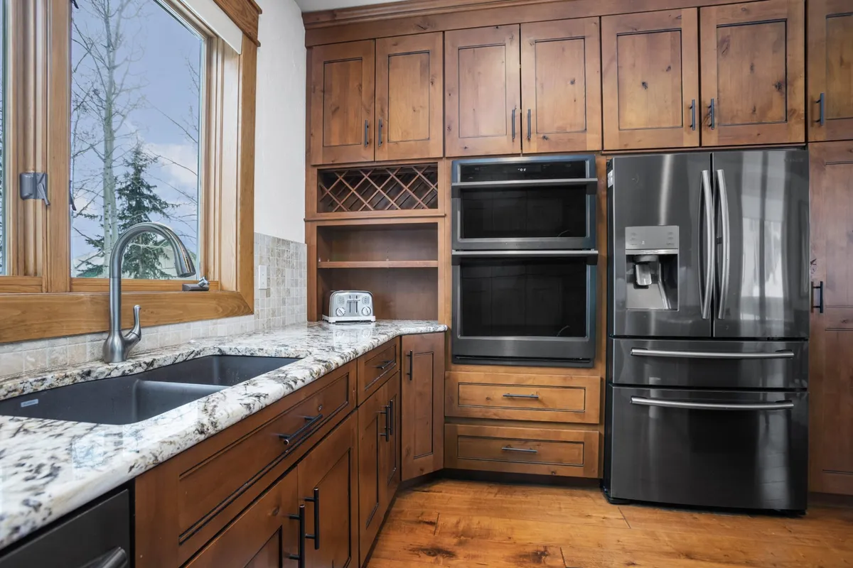 A sleek kitchen space with a granite countertop, stainless steel appliances, and wooden cabinets, designed for both efficiency and style. The layout is optimized for meal prep and socializing, perfect for home chefs and entertainers alike.